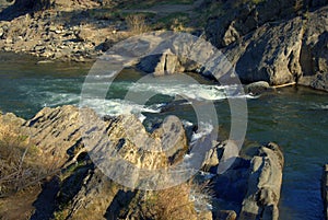 The raging stream of a mountain river wedged by stony shores. Altai, Siberia, Russia. Landscape