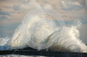 Raging waves crashing on a stone pier.