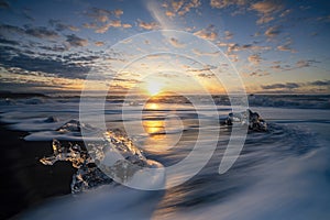 Raging waves smashing ice blocks at sunrise on Diamond Beach