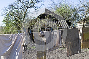 The rags are dried after washing against the background of a dilapidated house, slums and poor areas. Drying laundry
