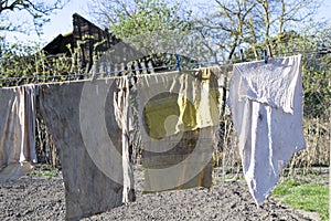 The rags are dried after washing against the background of a dilapidated house, slums and poor areas. Ð’rying laundry