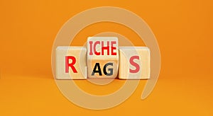 Rags or riches symbol. Concept word Rags Riches on wooden cubes. Beautiful orange table orange background. Business and rags or