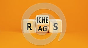 Rags or riches symbol. Concept word Rags Riches on wooden cubes. Beautiful orange table orange background. Business and rags or