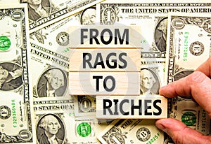 Rags or riches symbol. Concept words From rags to riches on wooden blocks. Beautiful background from dollar bills. Businessman