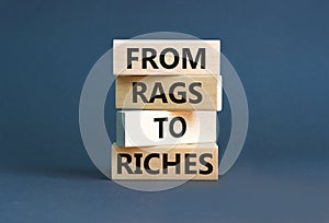 Rags or riches symbol. Concept words From rags to riches on wooden blocks. Beautiful grey table grey background. Business rags or