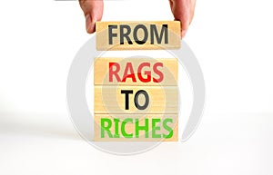 Rags or riches symbol. Concept words From rags to riches on wooden blocks. Beautiful white table white background. Businessman