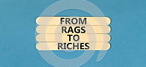 Rags or riches symbol. Concept words From rags to riches on wooden stick. Beautiful blue table blue background. Business rags or