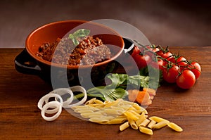 Ragu in bowl and raw macaroni photo