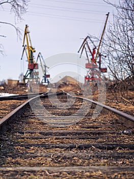 Rail road tracks under the gantry cranes on the berth of sea merchant port