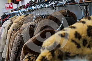 Rail of Secondhand Fur Coats For Sale in a Thrift Store Shop photo