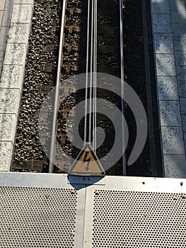 Rail tracks with high voltage warning sign