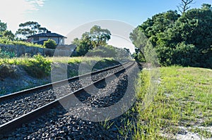 Rail tracks winding into the distance in rural area.