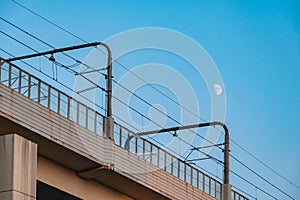 Rail transit catenary and the moon in the sky