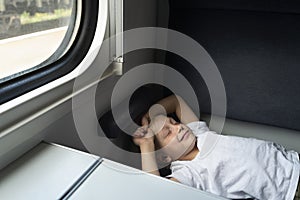 Rail travel. Boy is resting in compartment carriage. Comfortable train ride