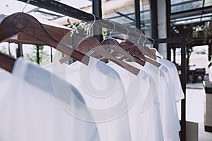 Rail with white t-shirts on hangers in the store