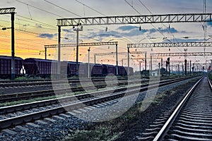 Railcar for dry cargo during beautiful sunset and colorful sky, railroad infrastructure, transportation and industrial concept