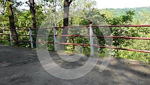 Railing on the side of a trail in the hills of Uttarakhand. Scenic trail on the outskirts of Dehradun in the midst of the forest,