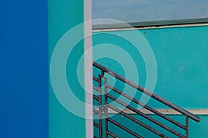 A railing of a staircase between blue beach shedsItaly, Europe