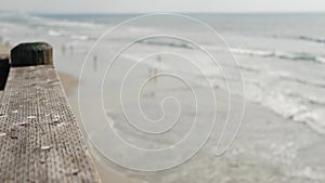 Railings of wooden pier, waterfront boardwalk, California beach USA. Defocused ocean, sea waves.