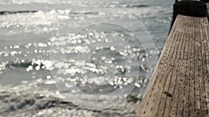 Railings of wooden pier, waterfront boardwalk, California beach USA. Defocused ocean, sea waves.