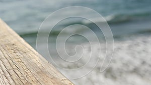 Railings of wooden pier, waterfront boardwalk, California beach USA. Defocused ocean, sea waves.