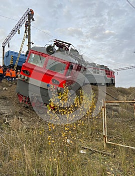The train derailed and ran off the embankment. The crew is repairing a derailed train photo