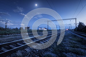 Railroad and blue sky with moon and clouds at night
