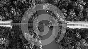 the railroad bridge crosses over the canal in black and white