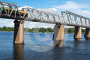 Railroad bridge in Kyiv across the Dnieper with freight train