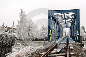 Railroad bridge in Litovel amongst the frost frosted trees in cold winter day photo