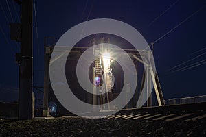 Railroad bridge over river at night, transportation construction