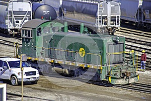 A railroad classification yard is filled with freight cars and EJ&E 323 waits to switch cars.