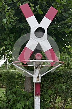 Railroad crossing without barrier, with warning sign and stop signal at an old railway line