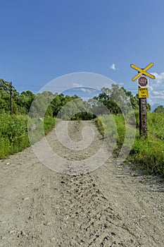 Railroad crossing with the dirt road and old stop sign