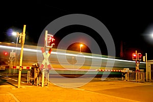 Railroad crossing at night with a Metro