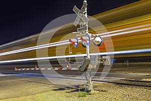 Railroad crossing by night with sign