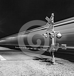 Railroad crossing with passing train by night