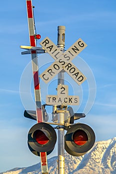 Railroad crossing sign with barrier and red lights