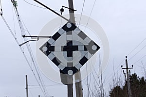 Railroad crossing sign and bell with beautiful cloudy sky in background .