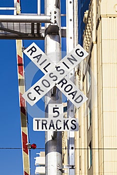 Railroad crossing sign with blue sky