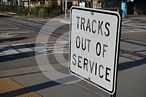 Railroad crossing sign indicates train tracks are inactive and out of service