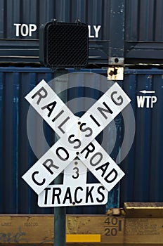 Railroad Crossing sign with Shipping Container Train in Background