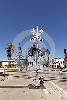 Railroad crossing sign under  blue sky