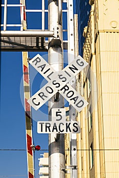 Railroad crossing sign under blue sky