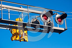 Railroad crossing signal post against blue sky in Michigan countryside