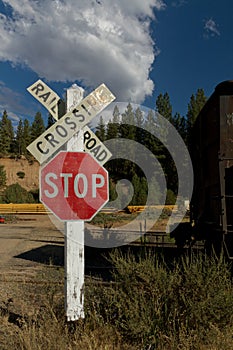 Railroad crossing with train on rails