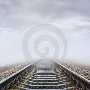 Railroad in fog to horizon in clouds