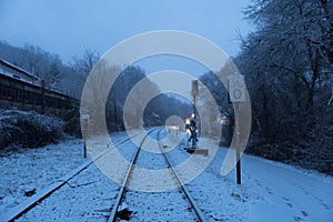 Railroad and foot path covered in snow on dark and gloomy day