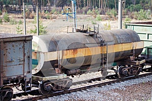 Railroad and freight train with rusty railway wagons going along forest. Transportain, cargo concept