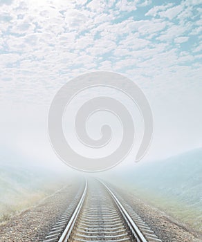 Railroad goes to foggy horizon